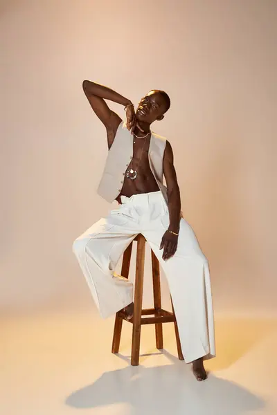 A young african american man poses confidently in stylish attire against a soft backdrop. — Stock Photo