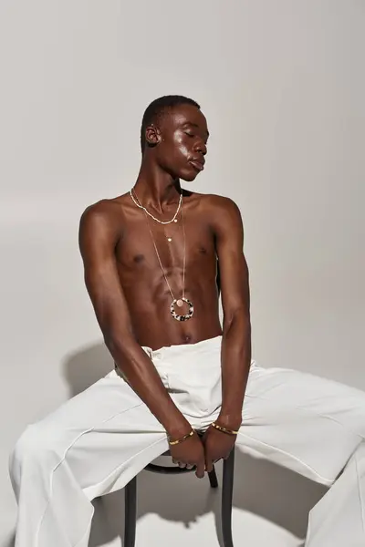 A stylish young man confidently showcases his unique fashion and striking accessories. — Stock Photo