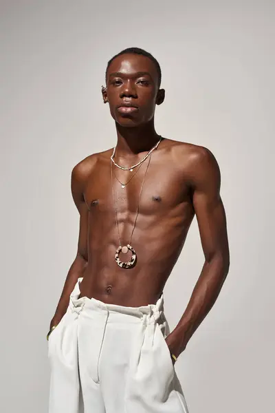 Young african american man exudes confidence in trendy attire, posing against a neutral backdrop. — Stock Photo