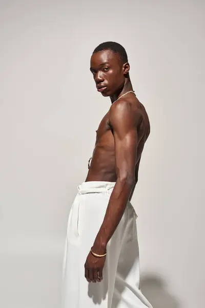 A young african american man stands confidently in stylish clothes, radiating energy and charm. — Stock Photo