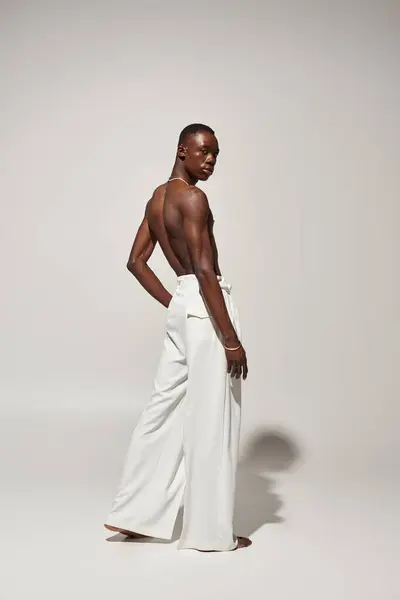 A young african american man confidently poses in stylish attire, exuding energy and charm. — Stock Photo