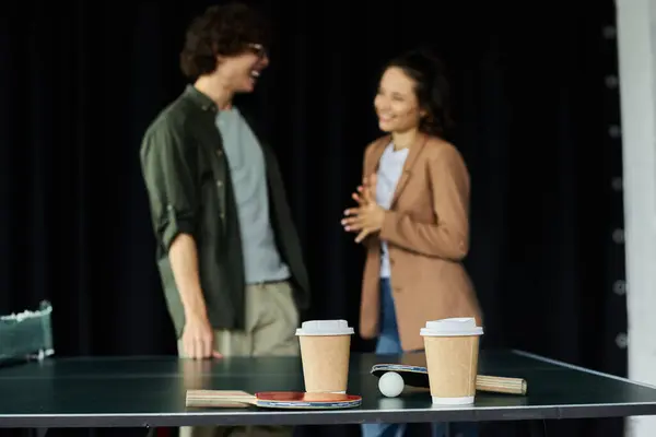 Zwei Kollegen genießen einen leichten Moment bei Kaffee und Gespräch in einem lebhaften Arbeitsbereich. — Stockfoto