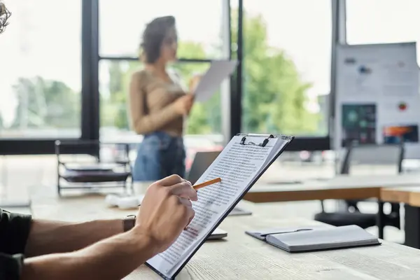 La gente trabaja junta en una oficina brillante, revisando documentos y compartiendo ideas. - foto de stock