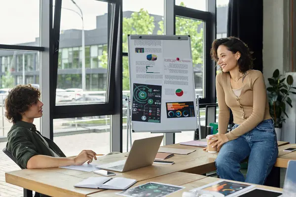 Two professionals share strategies in a bright workspace with engaging presentations. — Stock Photo