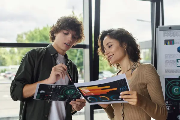 Two professionals engage in discussion over printed reports, sharing insights and strategies. — Stock Photo
