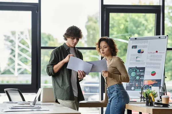 Two professionals engage in a constructive discussion while reviewing documents at work. — Stock Photo