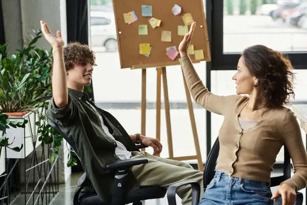 Zwei Kollegen brainstormen aufgeregt gemeinsam in einem modernen Arbeitsraum. — Stockfoto
