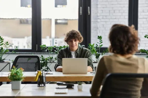 Dois profissionais colaboram em um escritório moderno, destacando a importância do trabalho em equipe. — Fotografia de Stock