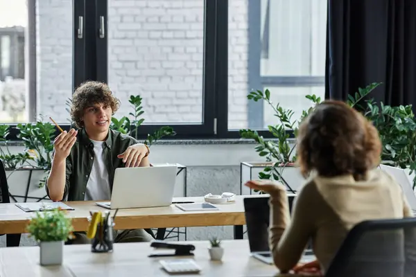 Two individuals actively discuss ideas and strategies in an inspiring office filled with greenery. — Stock Photo