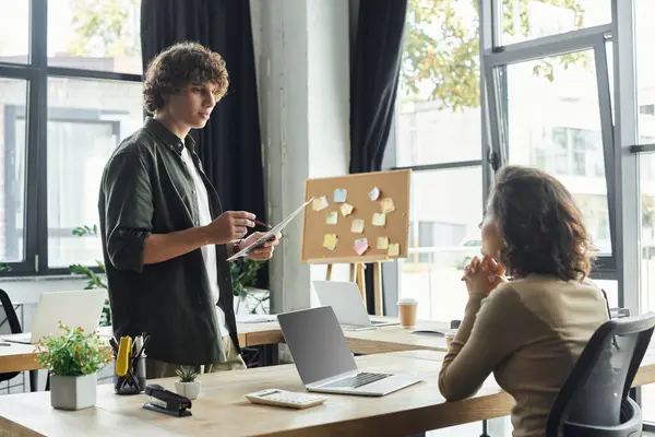 Two dedicated professionals engage in a dynamic discussion, surrounded by an inspiring workspace. — Stock Photo