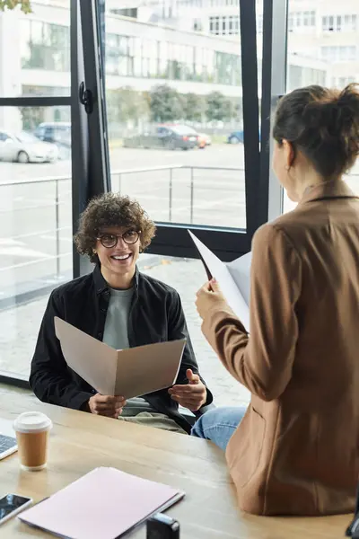 Two colleagues share ideas around a table in an inviting office, fostering creativity and teamwork. — Stock Photo