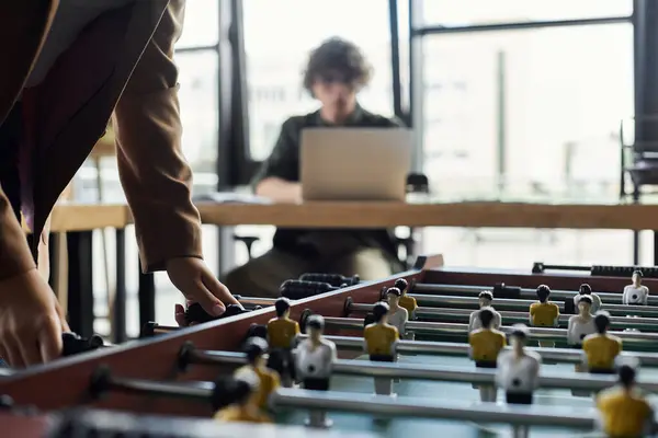 Colleagues play foosball in a bright, modern workspace while staying productive. — Stock Photo