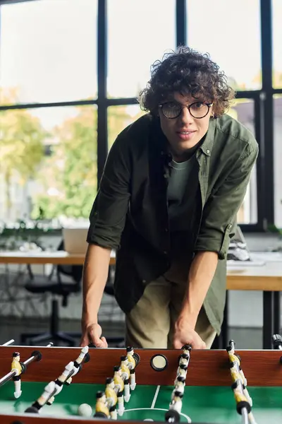 Colleagues enjoy a lively foosball match, showcasing camaraderie and teamwork in the workplace. — Stock Photo