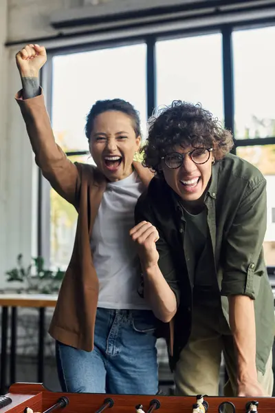 Two enthusiastic coworkers share a joyful moment in a bright office space, celebrating success. — Stock Photo