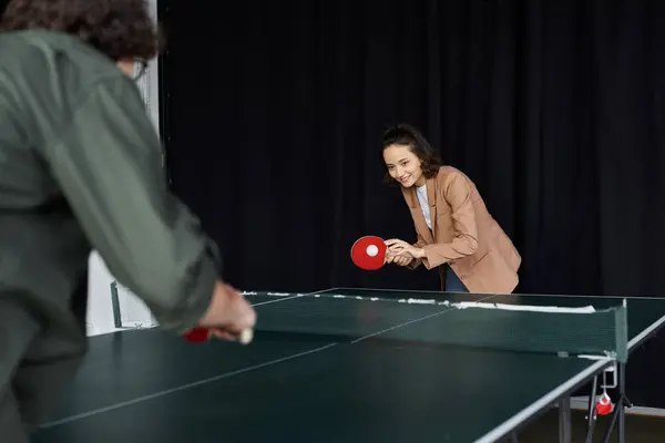 Two colleagues play ping pong in the office, boosting teamwork and camaraderie. — Stock Photo