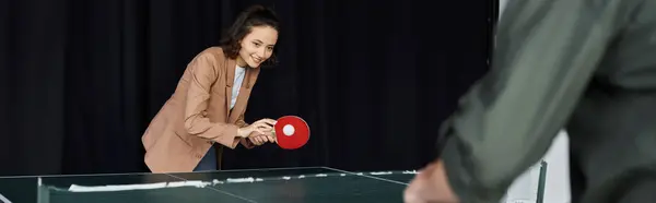 Colegas desfrutar de um jogo espirituoso de tênis de mesa, promovendo camaradagem e diversão no trabalho. — Fotografia de Stock