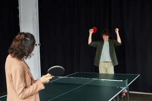Two colleagues engage in an energetic game of table tennis, showcasing teamwork and fun. — Stock Photo