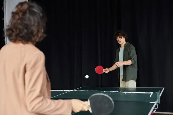 Two coworkers play table tennis, highlighting teamwork and camaraderie during their break. — Stock Photo