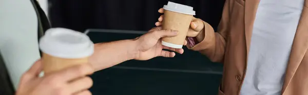 Due professionisti si impegnano in una conversazione mentre condividono tazze di caffè in un ambiente vivace ufficio. — Foto stock