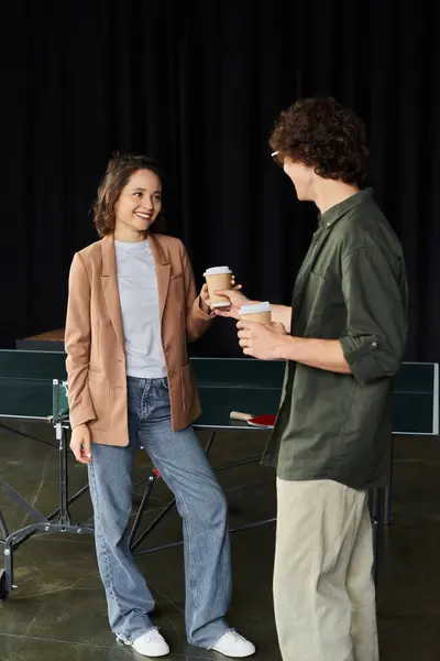 Zwei Mitarbeiter genießen in einer Pause Kaffee und Gespräche in einem ungezwungenen Büroraum. — Stockfoto