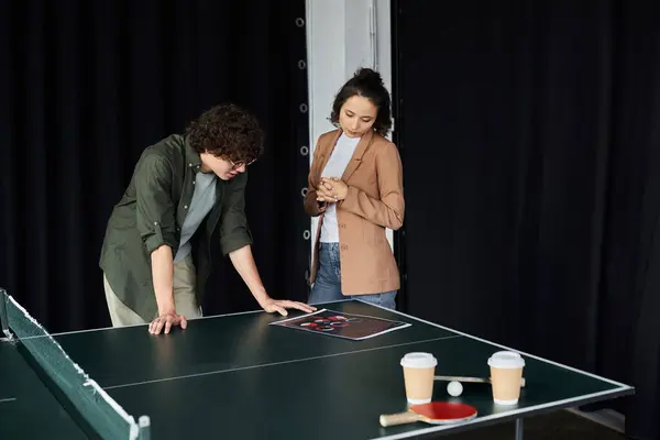 Dois colegas se envolvem em uma discussão estratégica ao analisar ideias sobre uma mesa de ping pong. — Fotografia de Stock