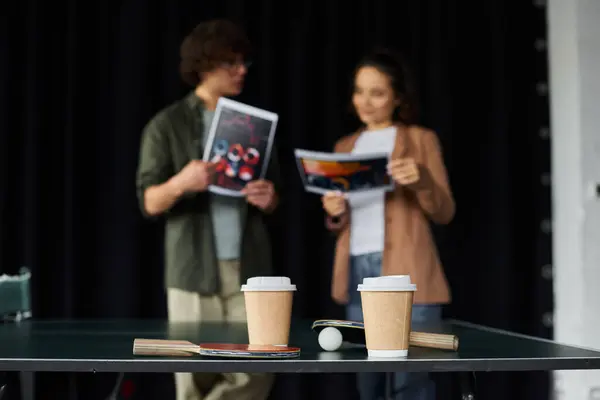 Zwei Kollegen plaudern bei Kaffee in einem lebendigen, modernen Büro über Projekte. — Stockfoto