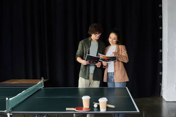 Two coworkers enthusiastically share ideas while standing by a ping pong table, collaborating. — Stock Photo