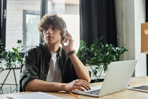 A dedicated worker engages with tech in a stylish, green filled office for task preparation. — Stock Photo