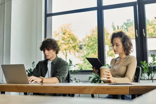 Two professionals work productively in a stylish office filled with plants. — Stock Photo