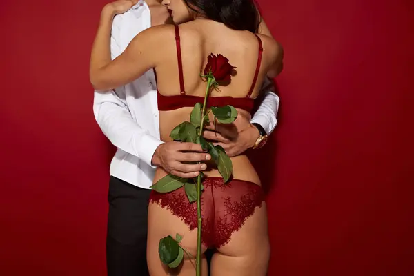 A couple shares a tender moment, expressing their passion in an intimate setting with warm tones. — Stock Photo