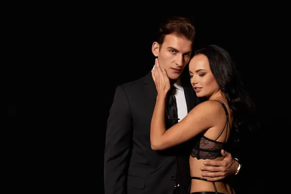 Um casal compartilha um abraço amoroso em um ambiente elegante durante a noite. — Fotografia de Stock