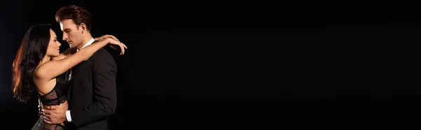 A couple shares an intimate moment, showcasing their deep connection in a dim light. — Stock Photo