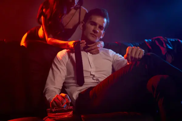 Ein leidenschaftliches Paar teilt einen verführerischen Moment in einer schwach beleuchteten Lounge, die Liebe und Versuchung ausstrahlt. — Stockfoto