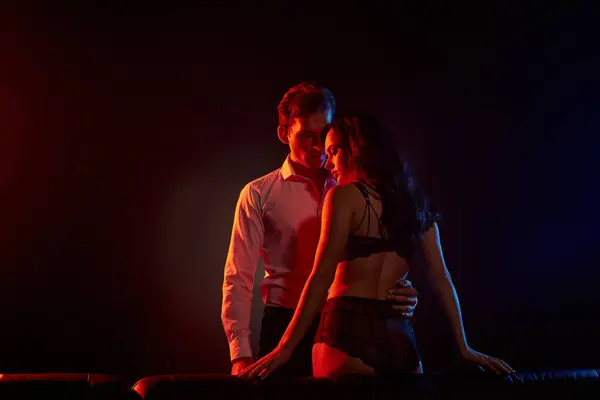 Um casal compartilha um momento apaixonado, destacando sua conexão profunda em luz suave. — Fotografia de Stock