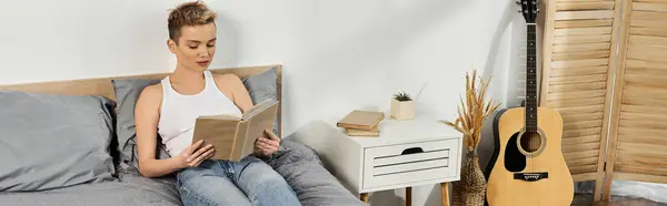 A young woman reads quietly on her bed, surrounded by a serene, minimalistic atmosphere. — Stock Photo