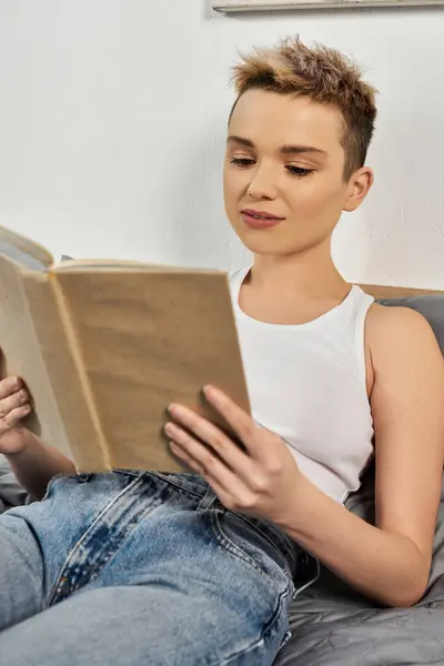 A young woman radiates confidence, immersed in her book, showcasing body positivity while relaxing. — Stock Photo