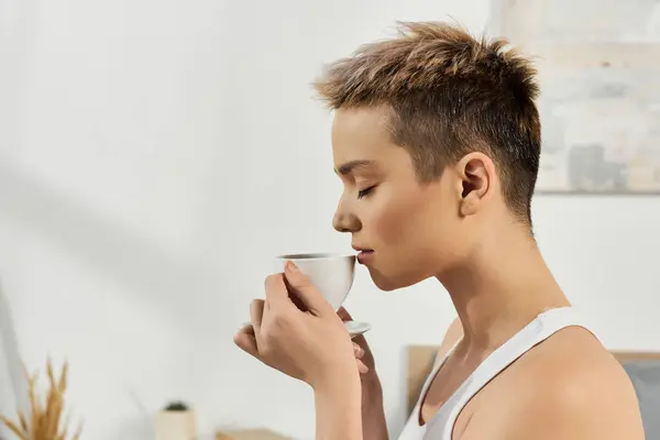 Mulher confiante com cabelos curtos saboreia uma xícara quente de café, incorporando positividade corporal. — Fotografia de Stock