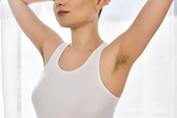 Una mujer joven abraza su belleza y positividad corporal, mostrando confianza en un entorno brillante. - foto de stock