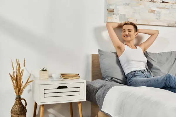 A young woman relaxes on her bed, showcasing a body positive attitude with self assured joy. — Stock Photo