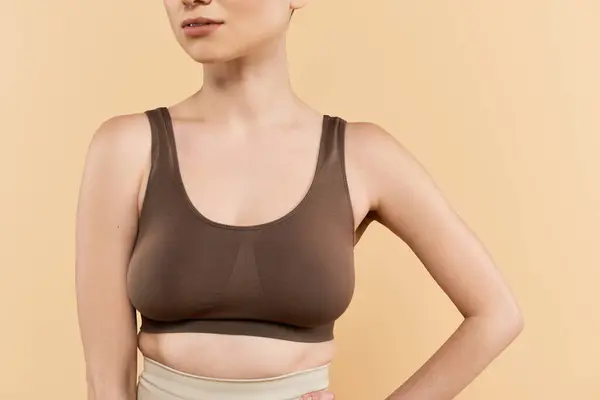 Une jeune femme rayonne de confiance et de beauté dans une tenue élégante sur un fond doux. — Photo de stock