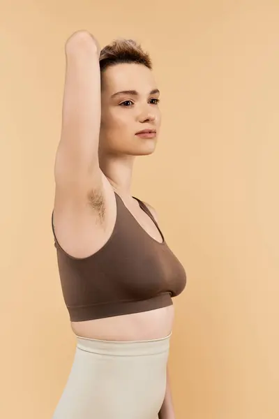 Una joven confiada se levanta elegantemente con la aceptación de sí misma, mostrando su belleza. - foto de stock