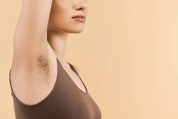Una mujer joven abraza su belleza natural y positividad corporal contra un telón de fondo suave. - foto de stock