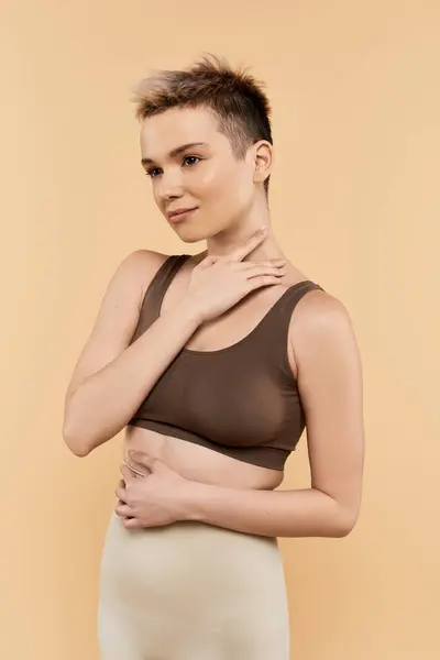 A beautiful young woman exemplifies body positivity with confidence against a warm backdrop. — Stock Photo
