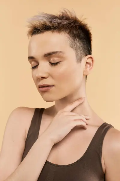 A young woman exuding body positivity with a calm expression against a warm background. — Stock Photo