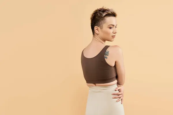 Mujer con el pelo corto muestra la positividad del cuerpo y la confianza en un traje elegante. - foto de stock