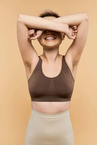 Young woman stands proudly, expressing body positivity and confidence against a warm backdrop. — Stock Photo