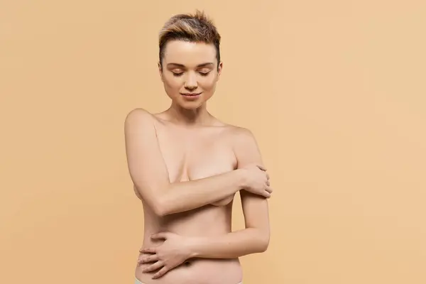 Une jeune femme confiante embrasse sa beauté, rayonnant de positivité sur un fond chaud. — Photo de stock