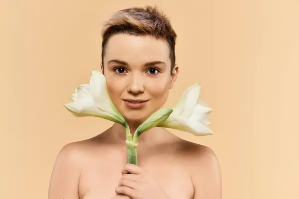 A young woman embraces body positivity while playfully holding flowers, radiating confidence. — Stock Photo