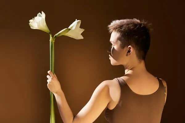 Beautiful young woman embraces body positivity, holding delicate flowers while radiating confidence. — Stock Photo