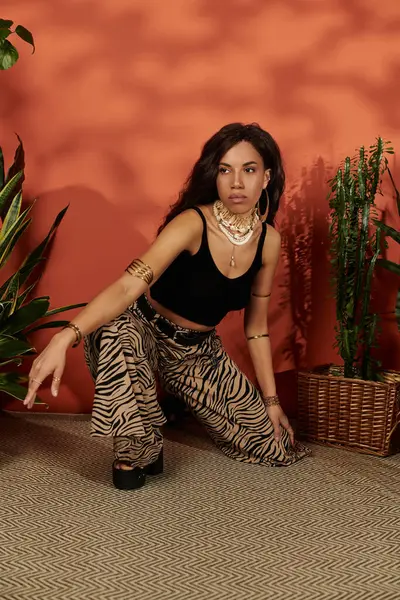 A beautiful young woman showcases her unique style amid green plants, exuding confidence and joy. — Stock Photo